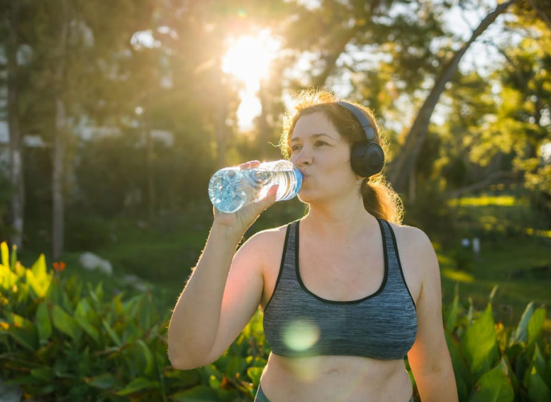 kobieta pijąca wodę podczas aktywności fizycznej